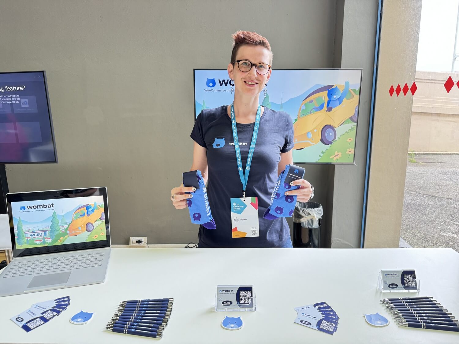 Ine standing behind Wombat Plugin's booth at WCEU 2024